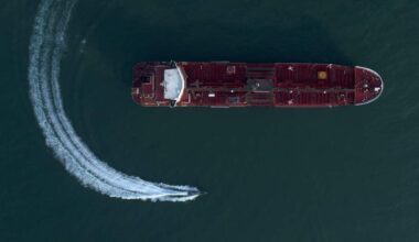 A large vessel and a much smaller boat in the ocean.