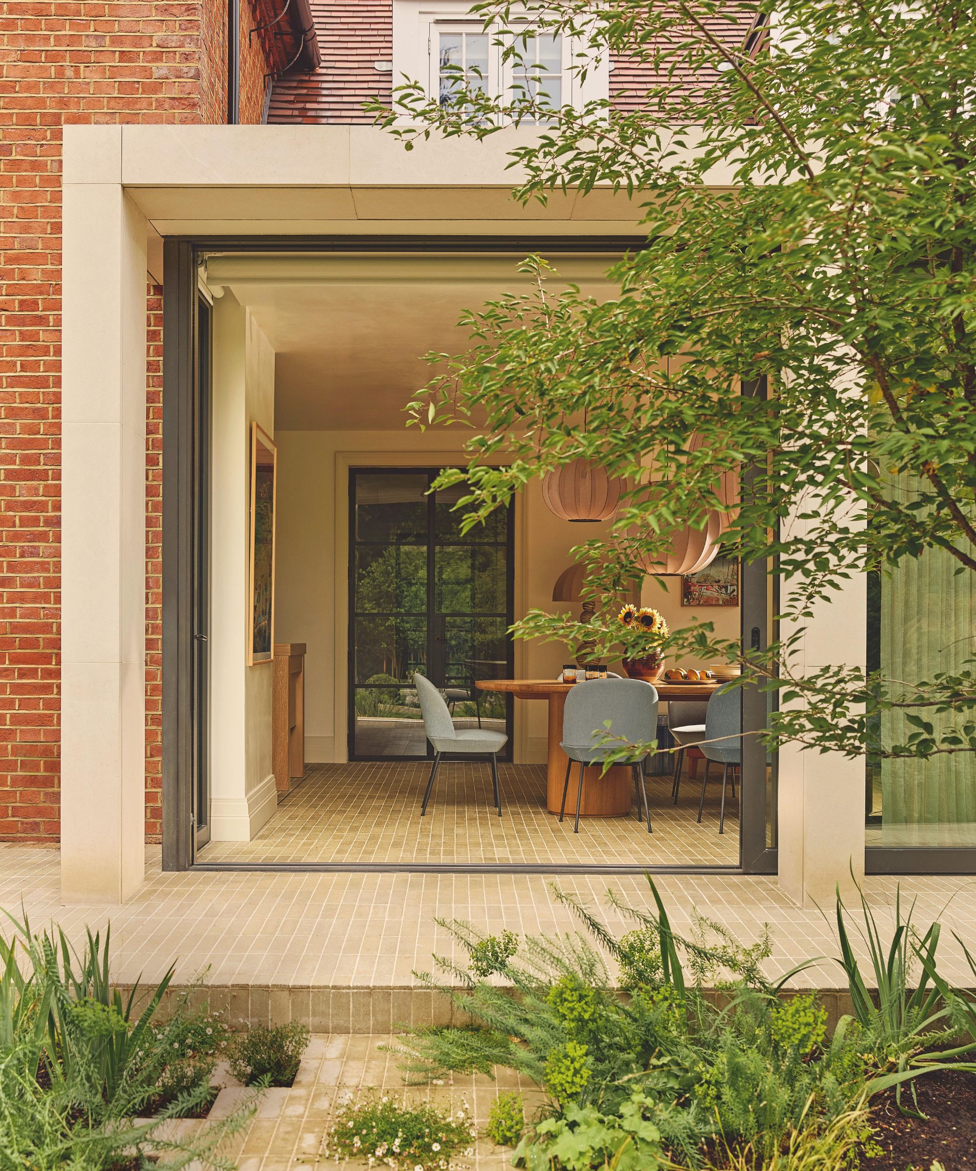 a view from the garden into a london home with a contemporary extension into the kitchen and dining space