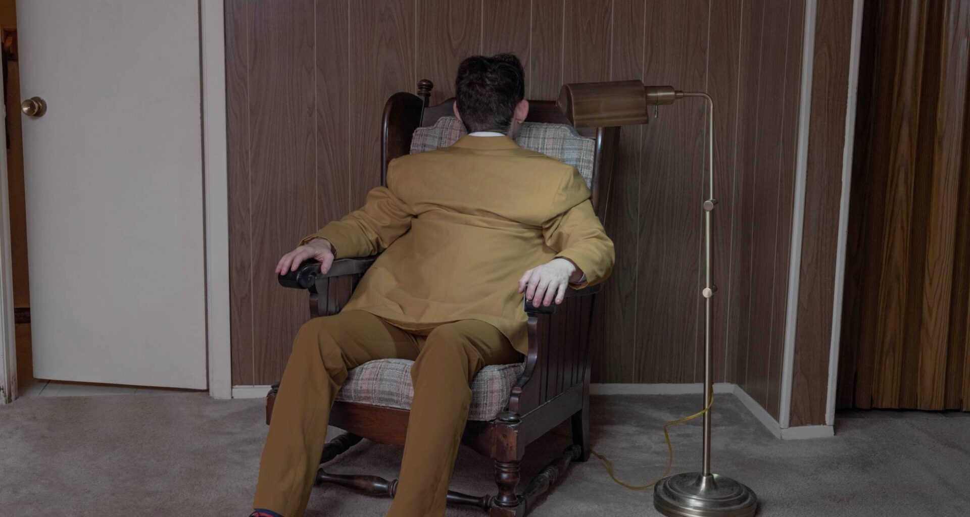 a surreal portrait by photographer Ben Zankn depicting a figure sitting at a seat, its head and back turned the opposite way