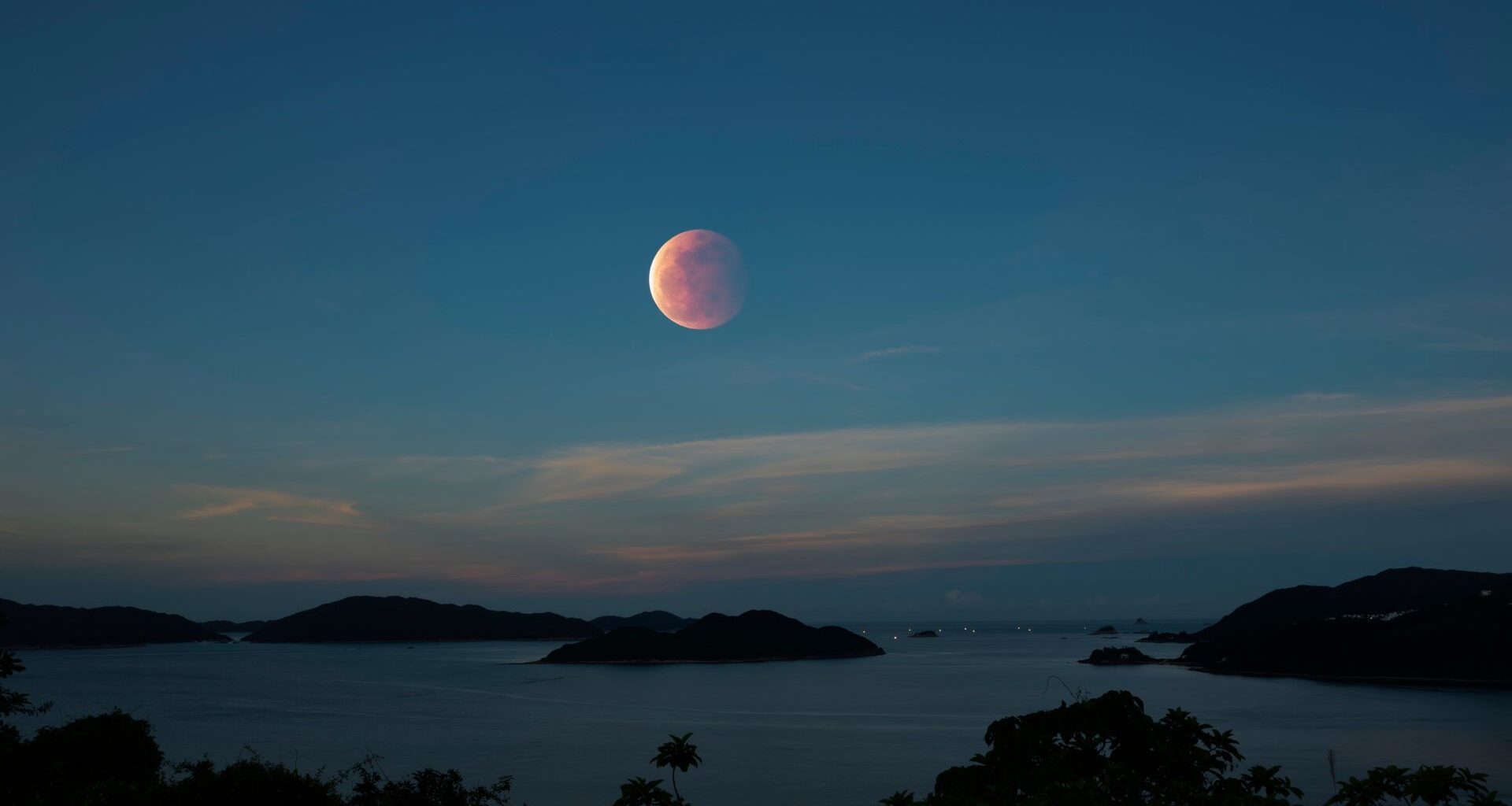 A Blood Moon full moon rises in the sky over Hong Kong
