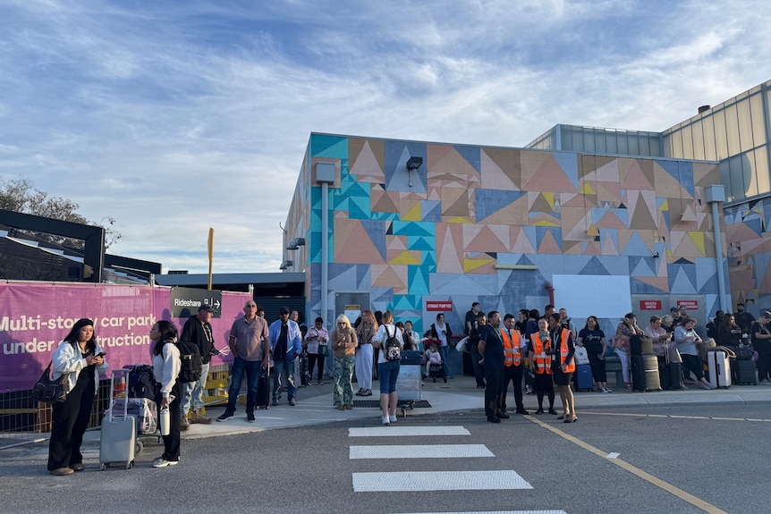 Passengers wait outside Perth airport. 
