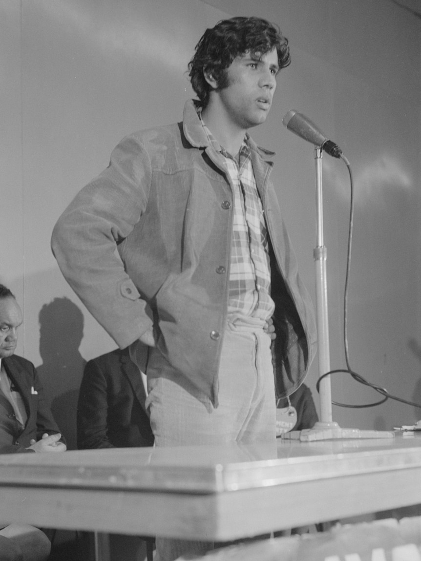 A man stands in front of a podium. 