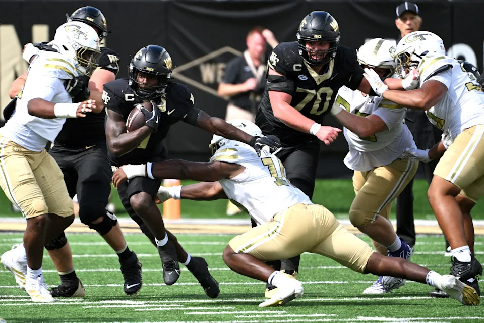 Sep 27, 2025; Winston-Salem, North Carolina, USA; Wake Forest Demon Deacons running back Demond Claiborne (1) runs the ball gainst Wake Forest Demon Deacons defensive back Zamari Stevenson (17) during the third quarter at Allegacy Federal Credit Union Stadium. Mandatory Credit: Zachary Taft-Imagn Images