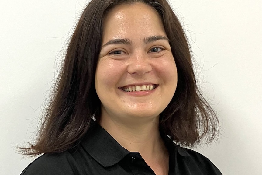 A smiling, dark-haired woman in a dark top.