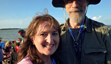 A woman and a man take a selfie outside during a NASA launch.