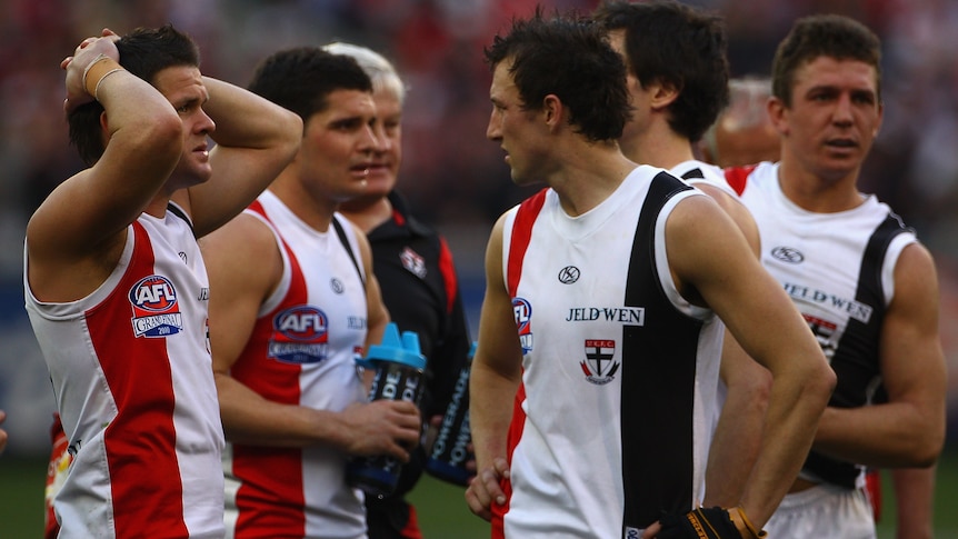 A group of tired and stunned St Kilda AFL players react after a grand final draw, including Steven Baker (right).