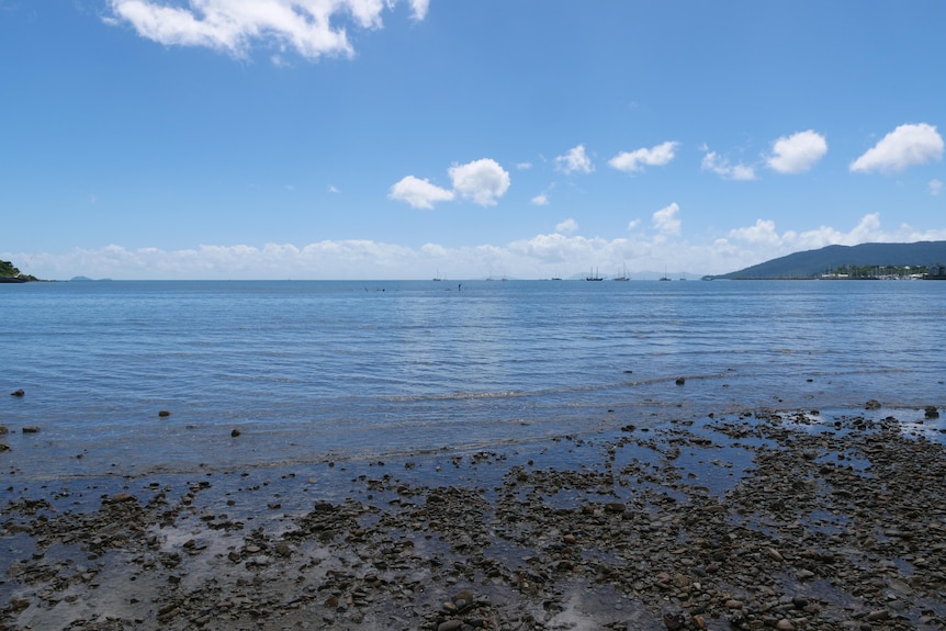 a beach with islands in the backgrounds, the sea dominating the frame