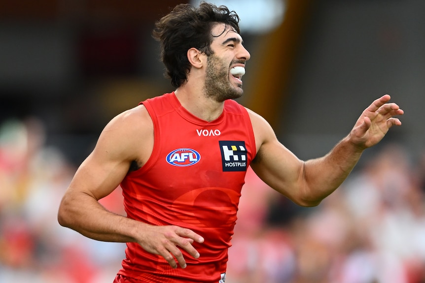 Christian Petracca of the Suns celebrates kicking an AFL goal against the Eagles.