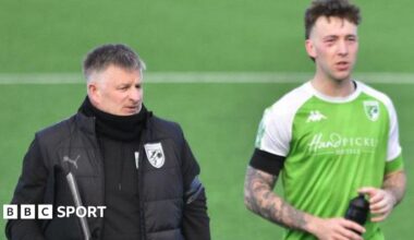 Guernsey FC boss Tony Vance with a player after the match on the pitch.