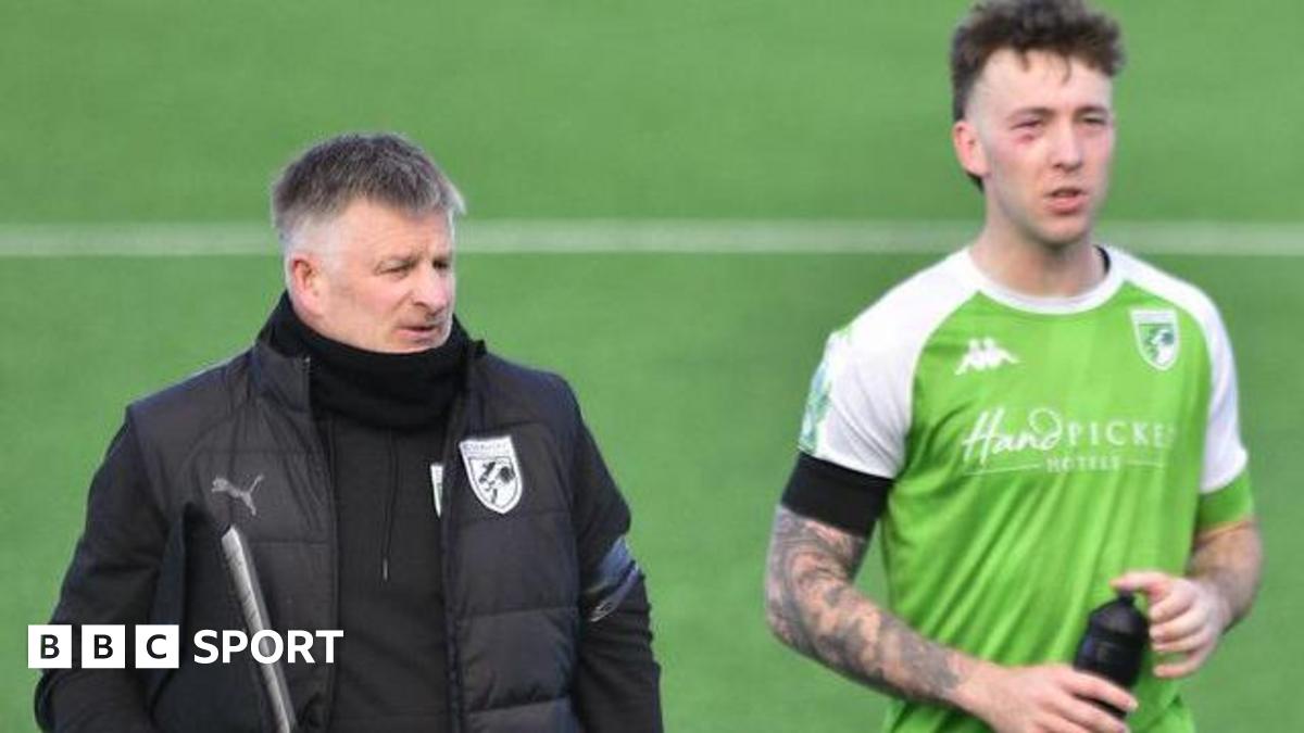 Guernsey FC boss Tony Vance with a player after the match on the pitch.