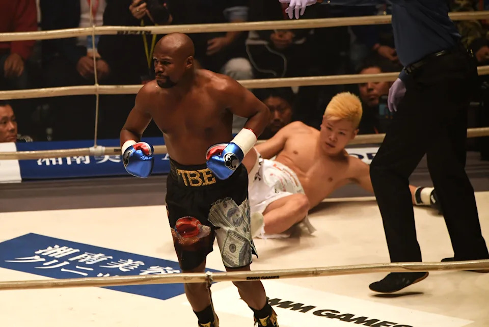 TOPSHOT - US boxing legend Floyd Mayweather Jr (L) knocks down Kickboxer Tenshin Nasukawa of Japan (C) during their exhibition match at Saitama Super Arena in Saitama on December 31, 2018. - Floyd Mayweather beat Japanese kickboxing phenomenon Tenshin Nasukawa by a technical knock-out in the first round of a New Year's Eve "exhibition" bout that brought the US boxing superstar out of retirement. (Photo by Toshifumi KITAMURA / AFP)        (Photo credit should read TOSHIFUMI KITAMURA/AFP via Getty Images)