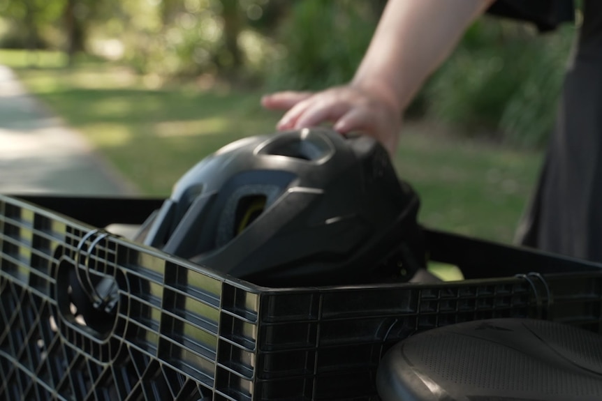 A hand reaching for a bike helmet.