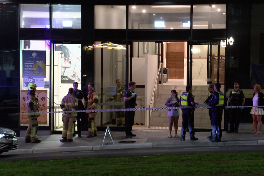 Police and residents outside a residential tower in Box Hill