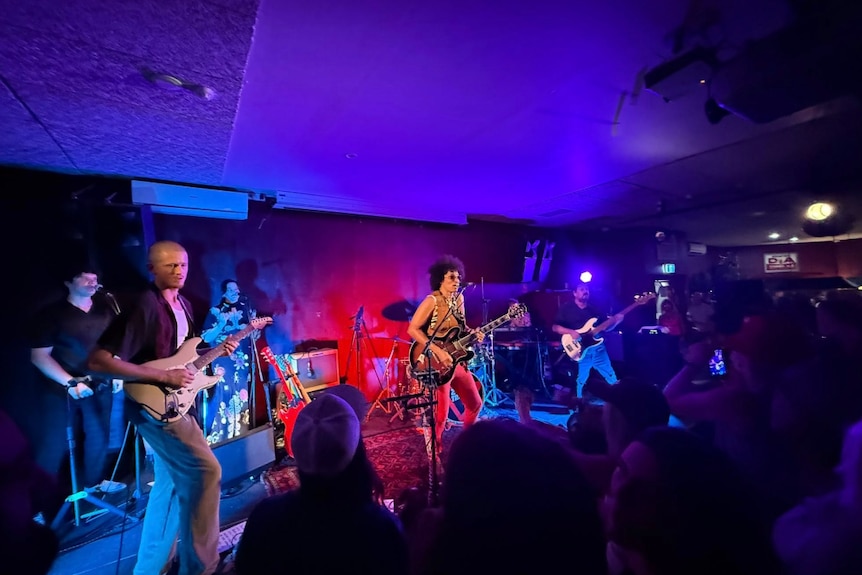 A six-piece band plays in a pub.