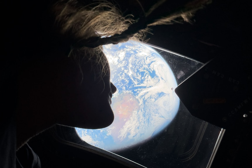Christina Koch silhouette looks back at Earth from Artemis