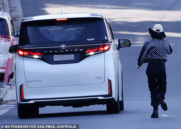 Yang (above) dresses head to toe in designer clothing, routinely runs away when approached by reporters, and almost always wears a face mask