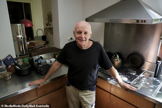 He said going 'off grid' made him feel lighter and freer (pictured in his kitchen)