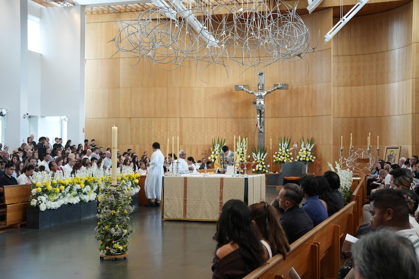 A bright room filled with people attending a church service
