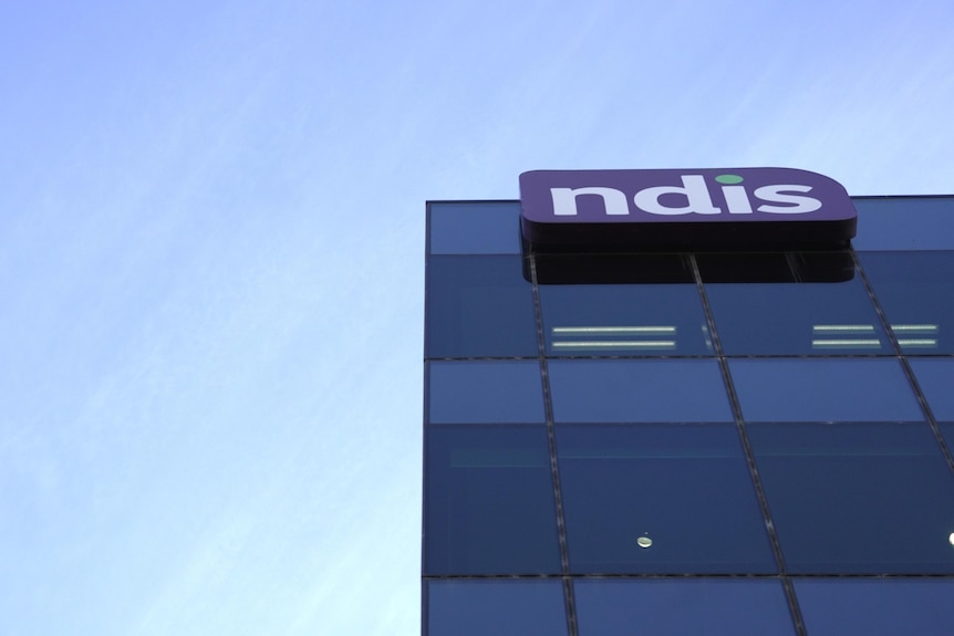 A photo of an NDIS logo at the top of a glass guilding