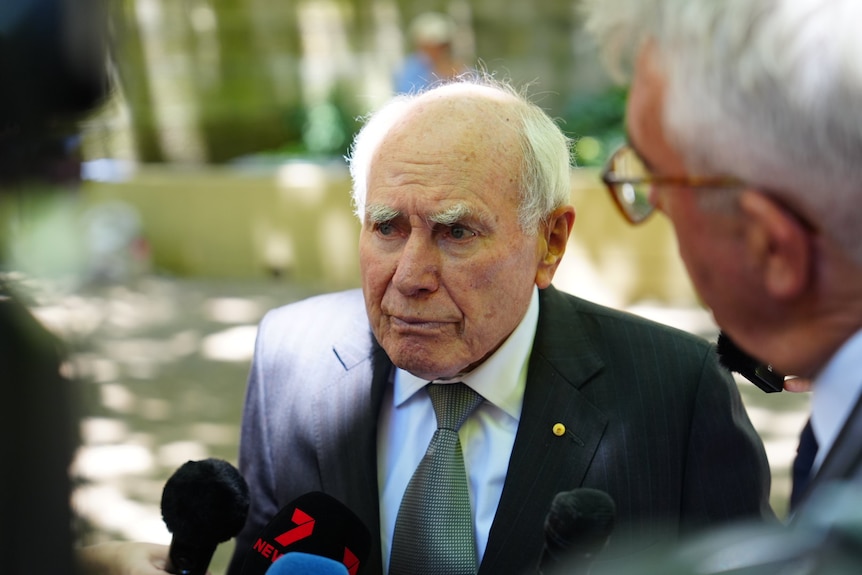 John Howard wearing a dark suit and tie