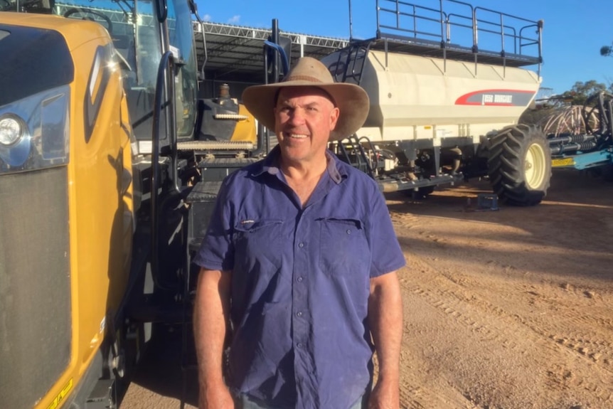 A grain grower standing in front of machinery