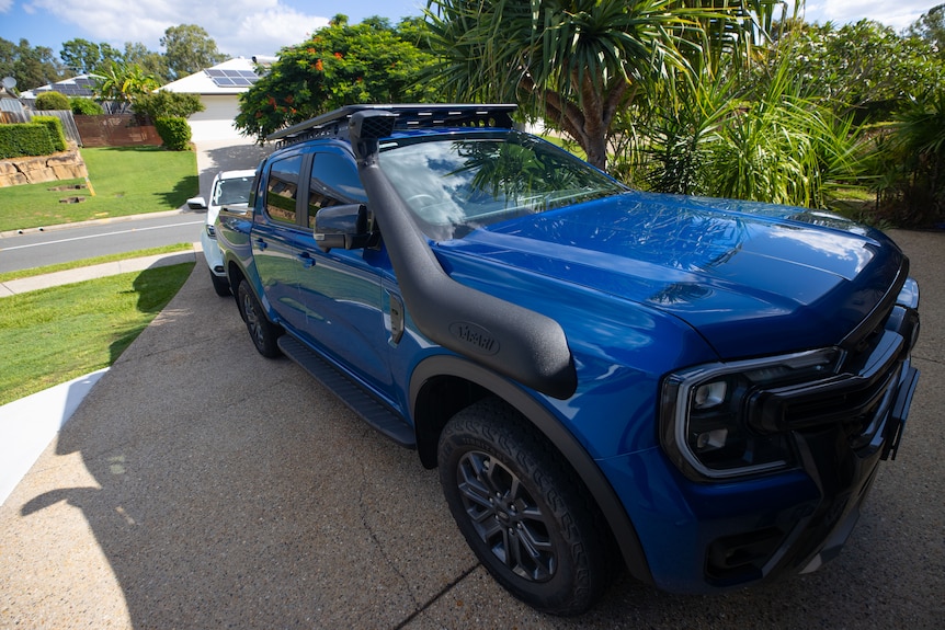 A blue ute in a driveway.