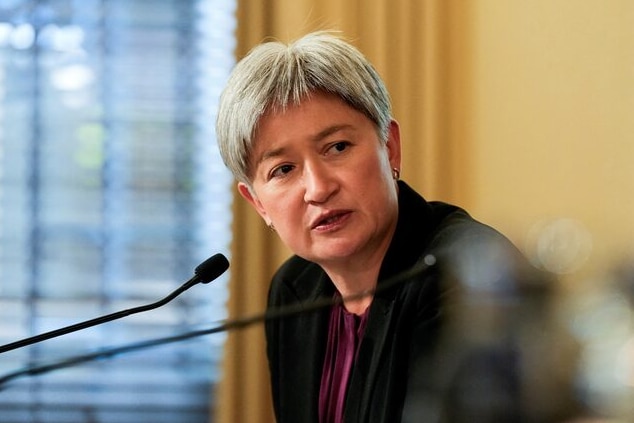Penny Wong leaning into a microphone
