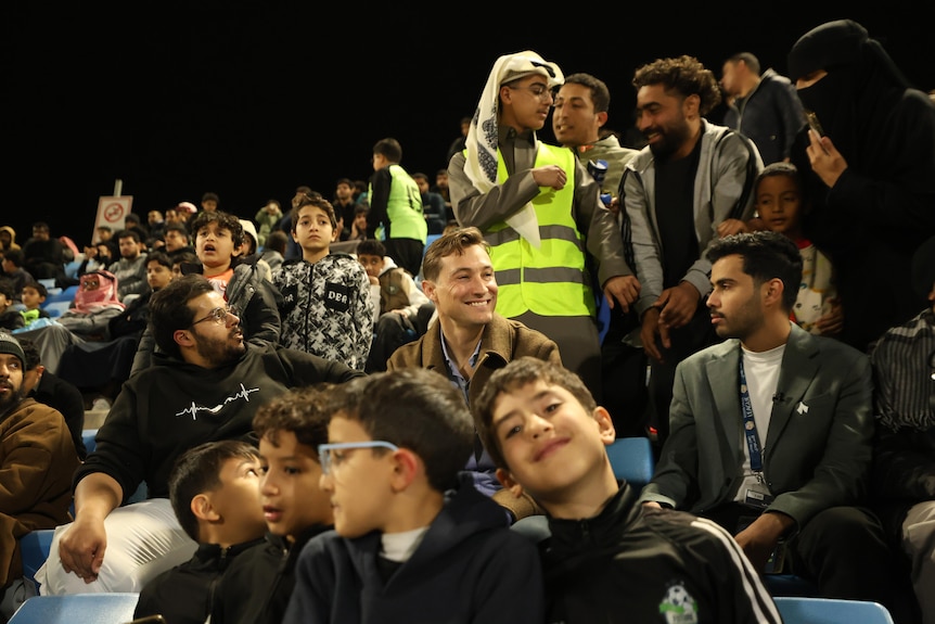 A man in the stands at a football game.