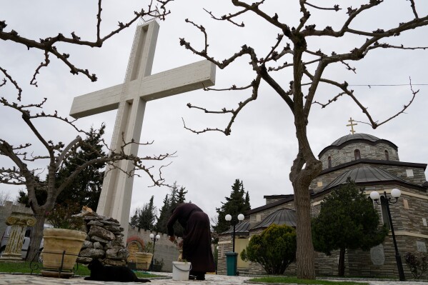 A monk tends to plants at the Monastery of St. Augustine and Seraphim of Sarov in the village of Trikorfo, about 236 kilometers (147 miles) northwest of Athens, Friday, March 20, 2026. (AP Photo/Thanassis Stavrakis)