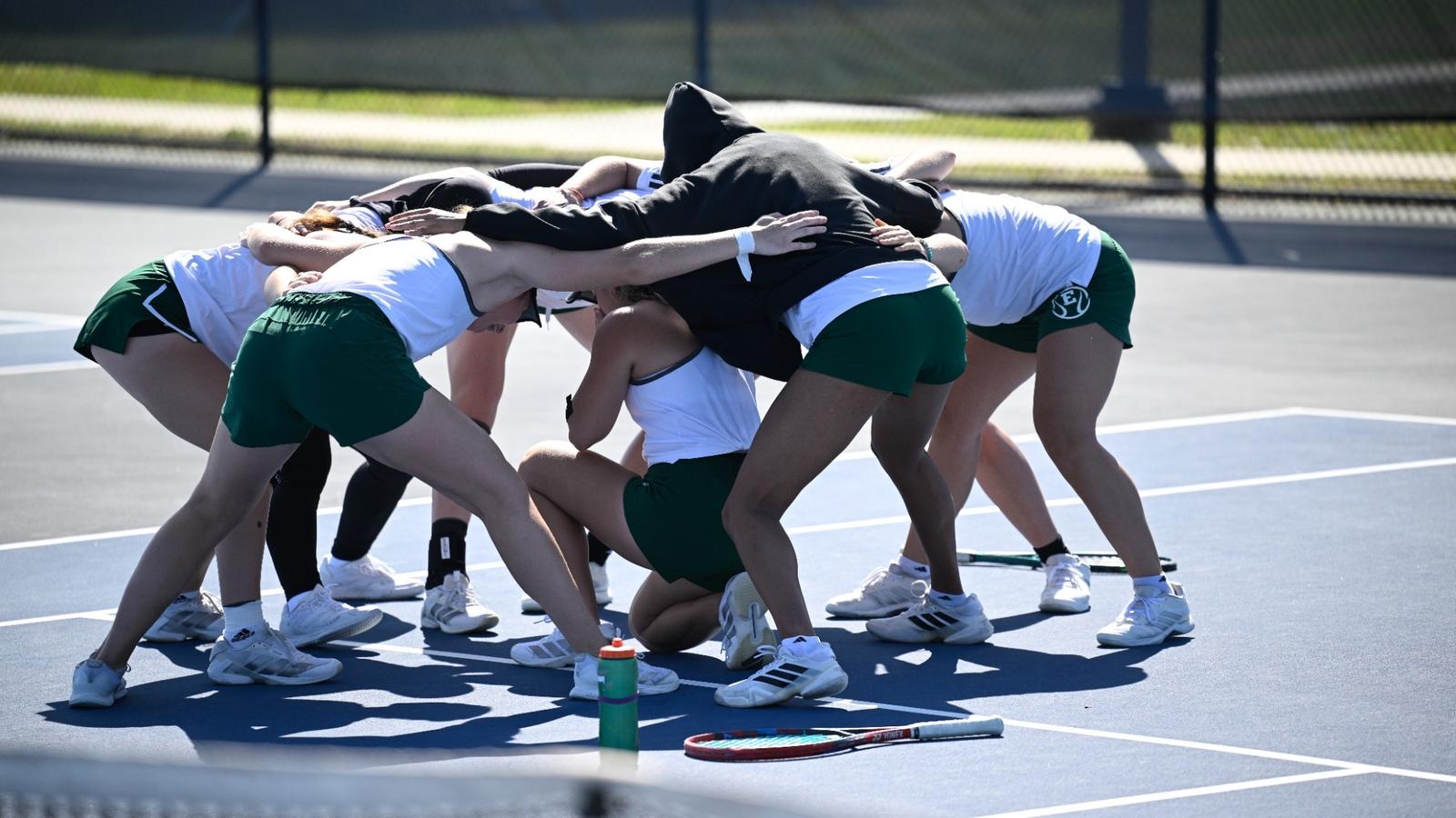 The 2025-26 tennis team huddles on the court at the Chippewa Club before playing its match against visiting Oakland