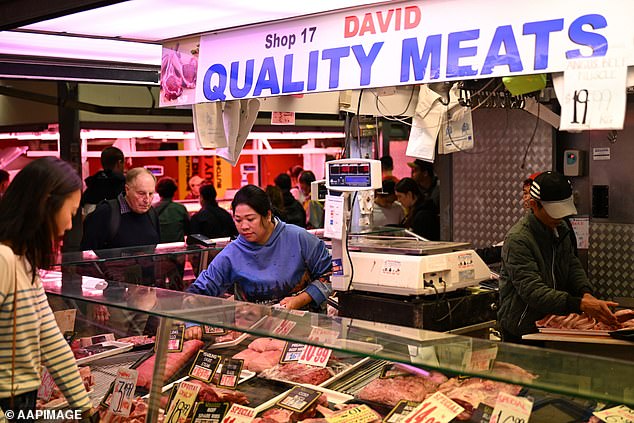 People are seen shopping a butchers store at the Queen Victoria Market in Melbourne, Saturday, March 22, 2025. (AAP Image/James Ross) NO ARCHIVING