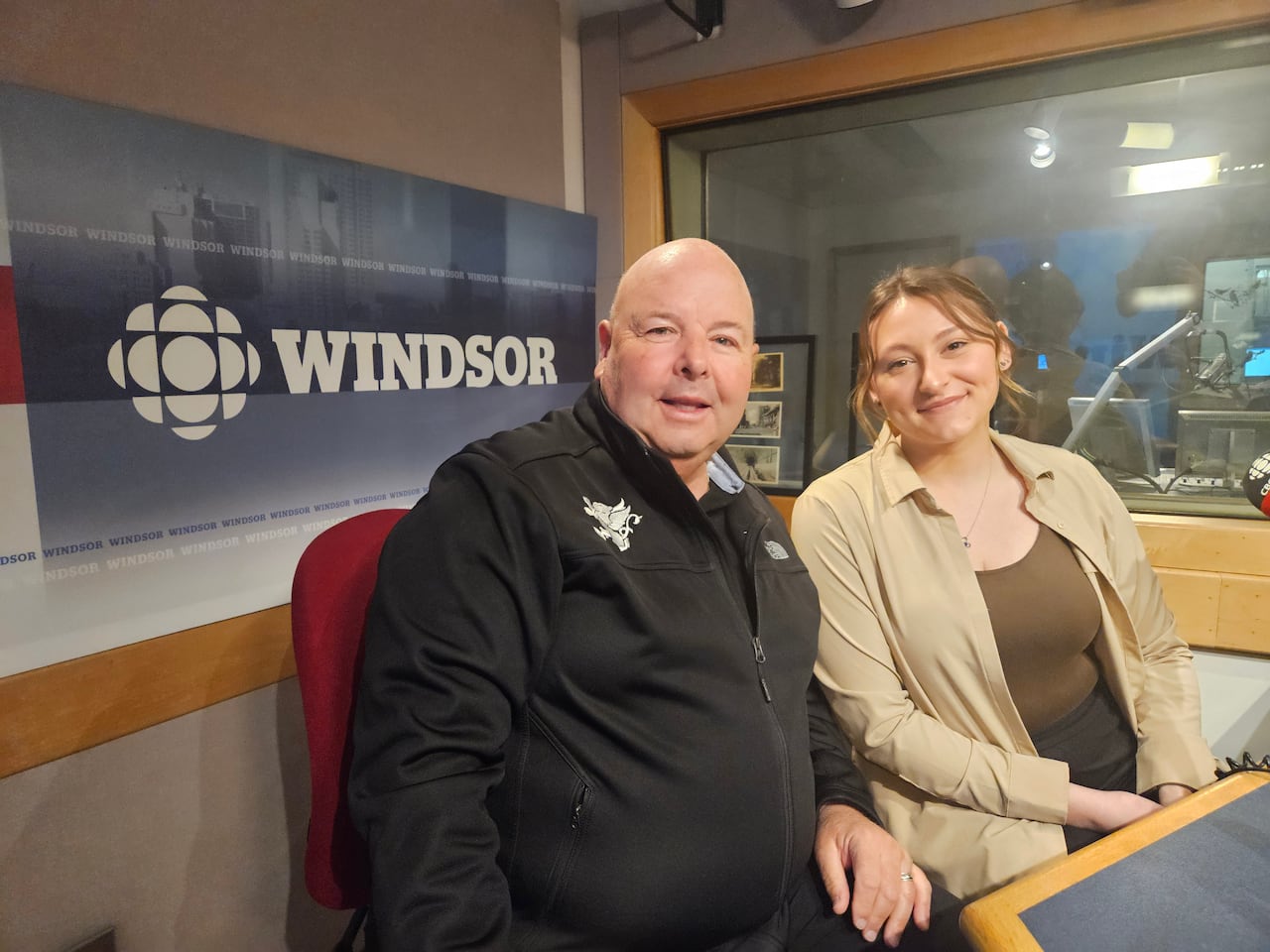 A man and woman smile at the camera at a CBC studio