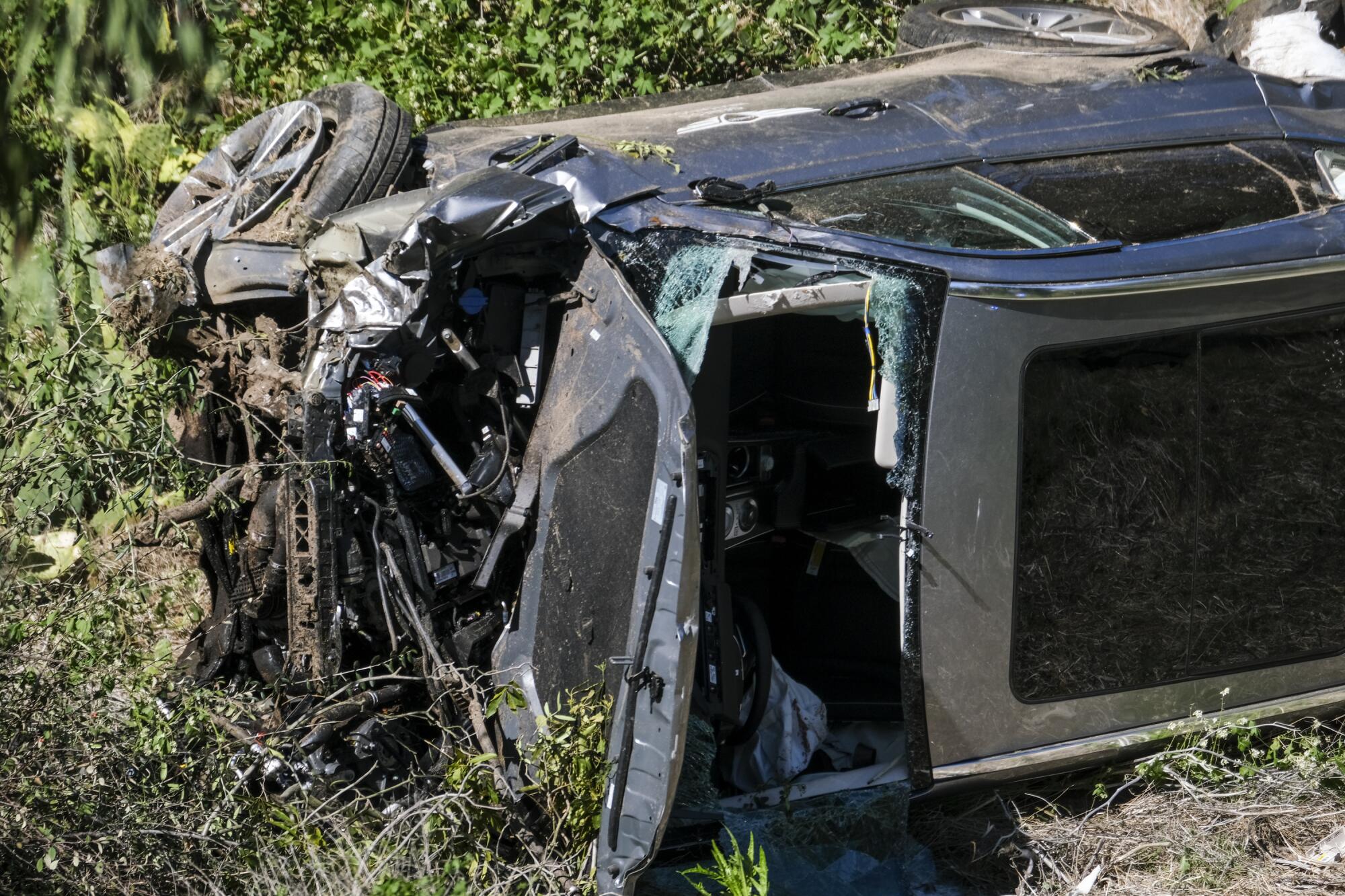 A vehicle rests on its side after a rollover accident involving golfer Tiger Woods along a road in the Rancho Palos Verdes 