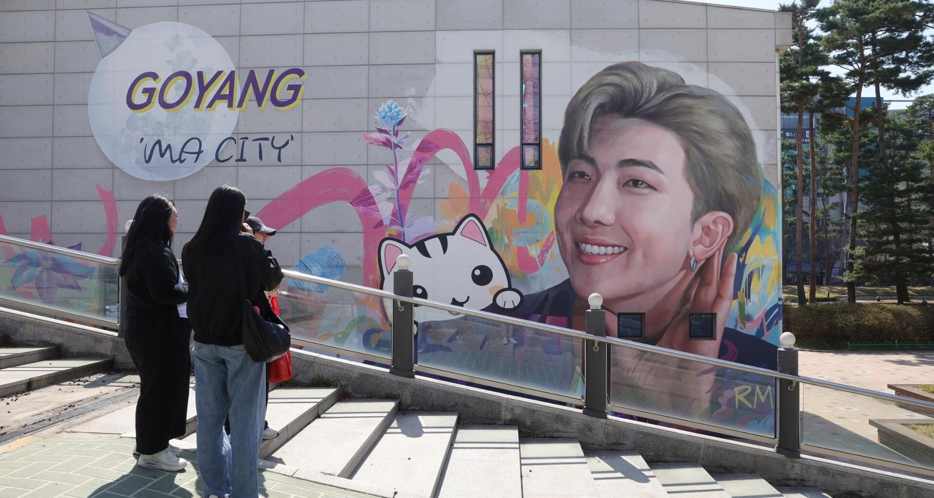 Fans take a look at a mural of BTS