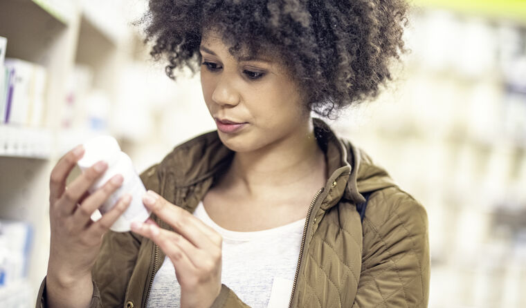A woman reading medication bottle