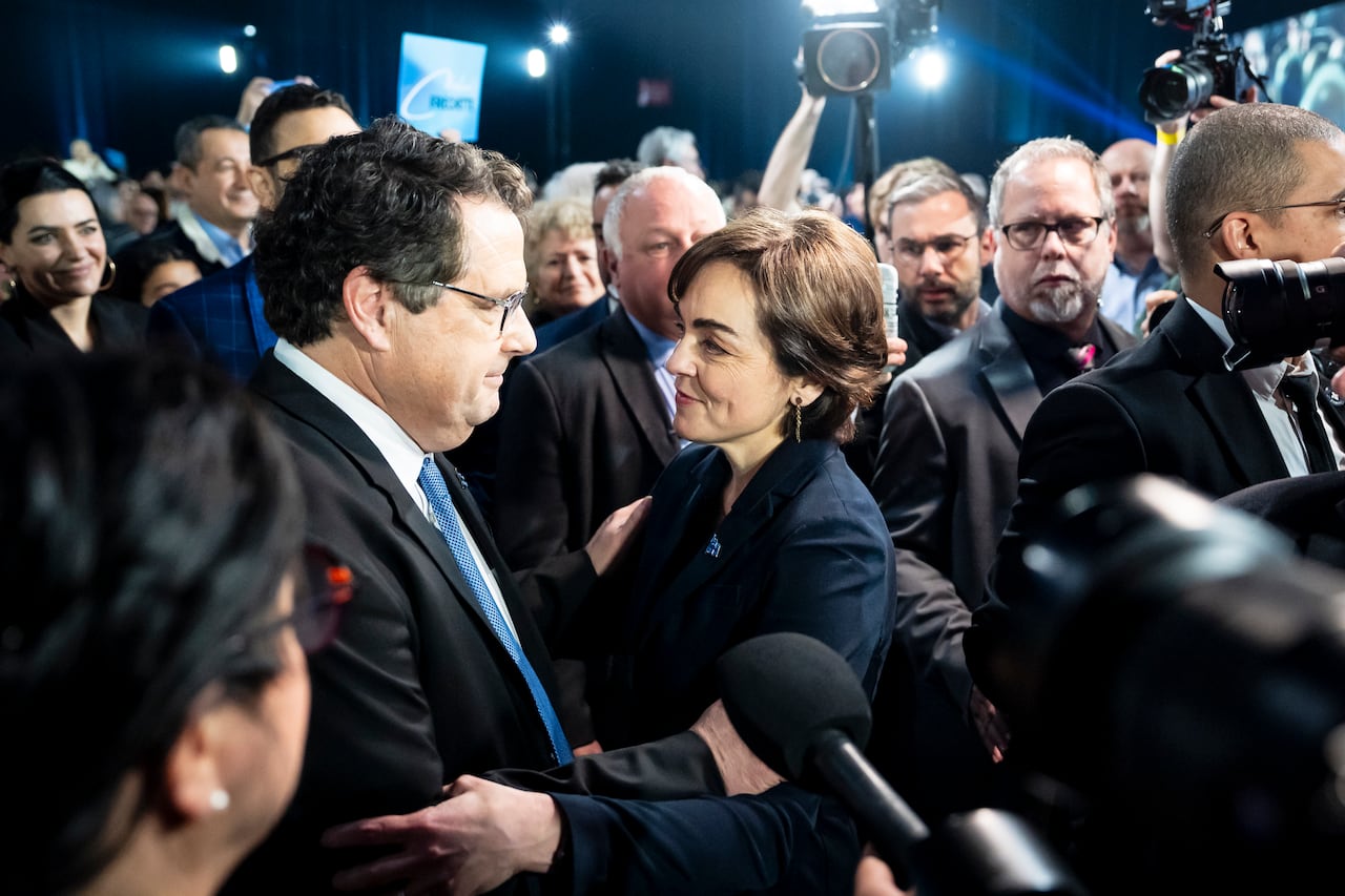 two people talking surrounded by others