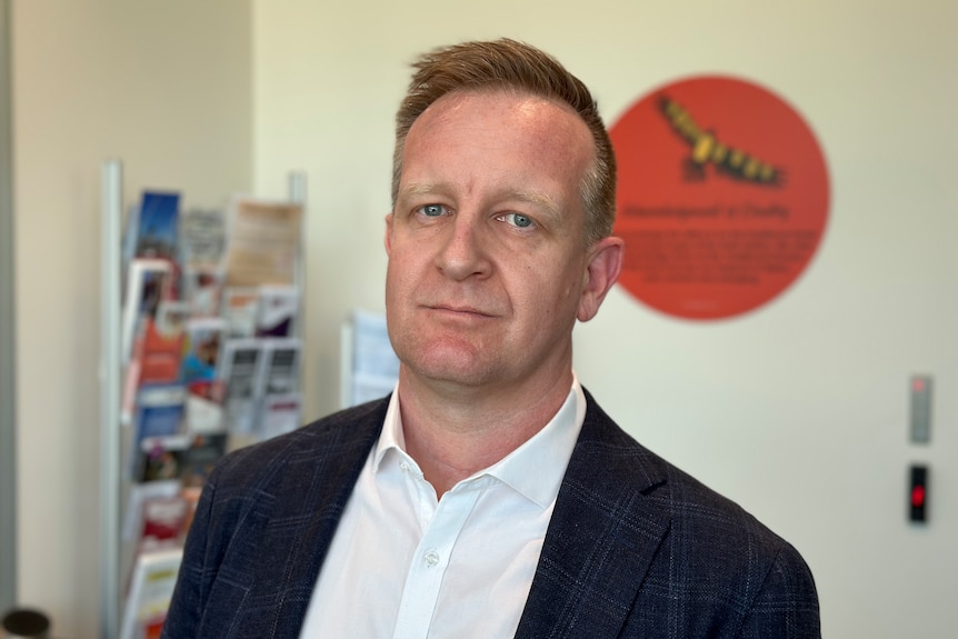 A middle-aged man photographed indoors, looking directly at the camera