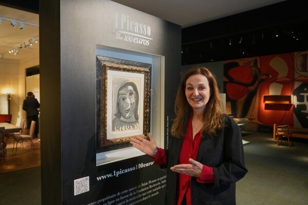 Peri Cochin, co-founder of the "1 Picasso for 100 euros" poses next to Head of a Woman by Pablo Picasso, painted in 1941, in Paris, Friday, April 10, 2026, ahead of a lottery in which the painting is being raffled off to raise money for Alzheimer’s research. (AP Photo/Michel Euler)