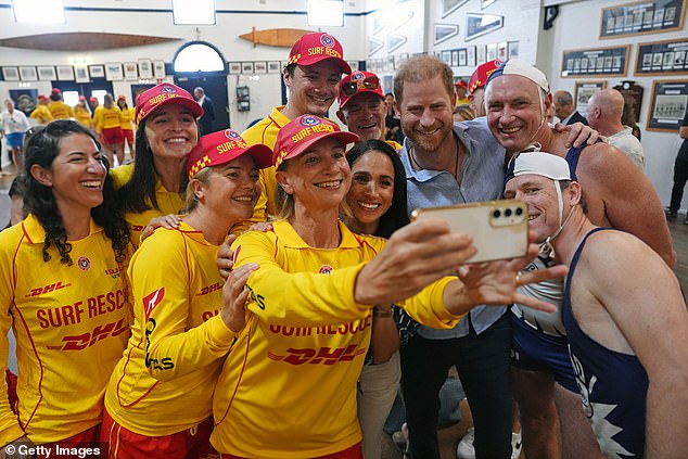 SYDNEY, AUSTRALIA - APRIL 17: Meghan, Duchess of Sussex and Prince Harry, Duke of Sussex pose for a selfie photo as they meet volunteer first responders from Bondi Surf Bathers' Life Saving Club, during a visit to Bondi Beach, on day four of the royal trip to Australia on April 17, 2026 in Sydney, Australia. Volunteers from the organisation, founded in 1907, played an integral role in protecting beachgoers and saving lives during the terrorist attack at Bondi Beach on December 14. (Photo by Jonathan Brady-Pool/Getty Images)