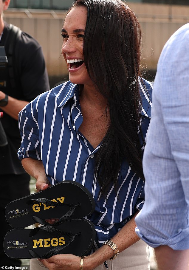 SYDNEY, AUSTRALIA - APRIL 17: Meghan, Duchess of Sussex is presented with custom thongs which reads "G'Day Megs" by Invictus Australia veteran Joel Vanderzwan at the Sydney Opera House on April 17, 2026 in Sydney, Australia. The Duke and Duchess of Sussex are on a four-day visit to Australia, with engagements across Melbourne, Canberra and Sydney. (Photo by Cameron Spencer/Getty Images)
