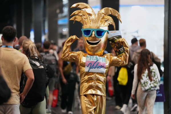 A man dressed as a golden palmtree promotes protein food supplements at the health & fitness trade show FIBO in Cologne, Germany, Friday, April 17, 2026. (AP Photo/Martin Meissner)