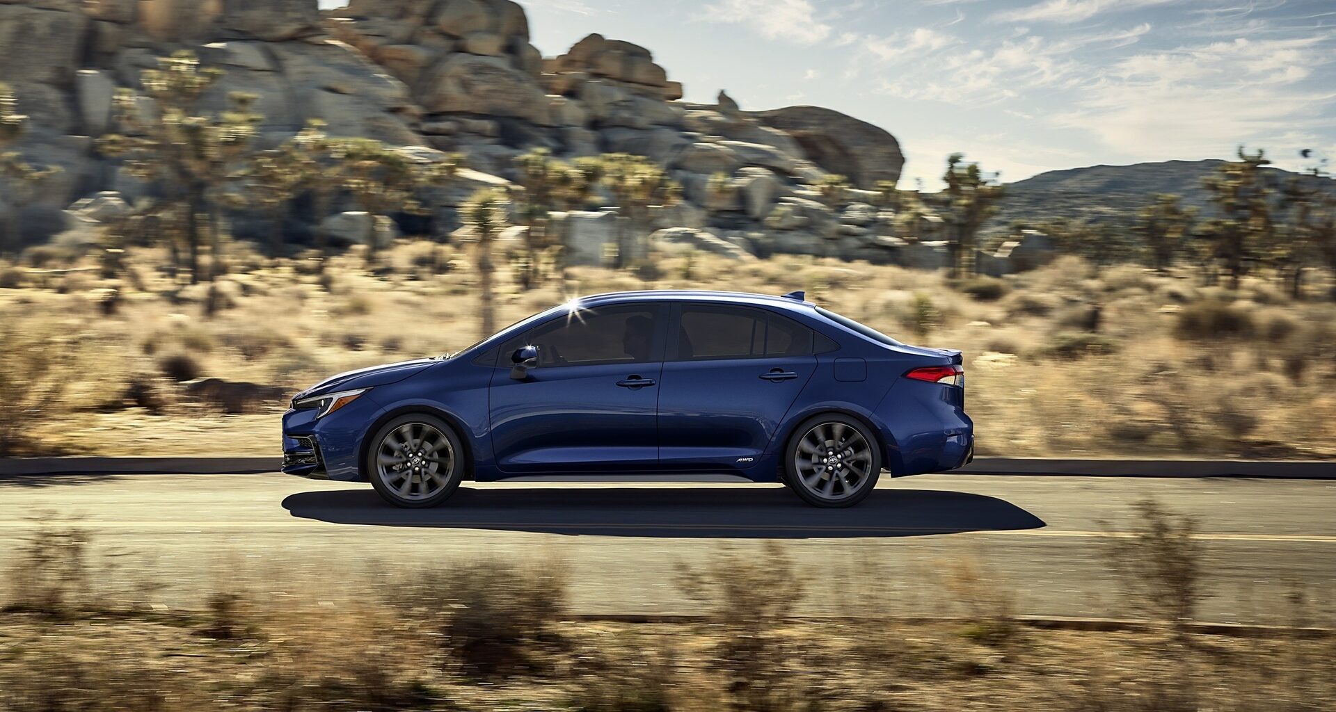 2025 Toyota Corolla Hybrid driving on a desert road for promotional photo.
