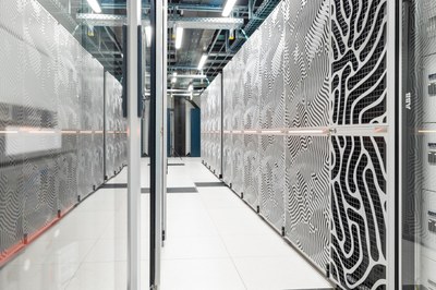 A bright, modern data center with multiple rows of server racks and visible cabling overhead. (Mistral: Pixtral Large 2411, 2026-04-23)