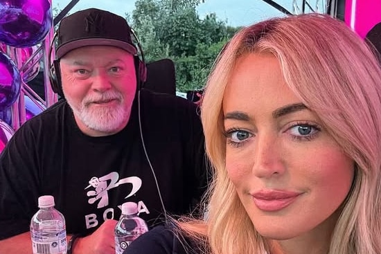 A selfie of Jackie O Henderson smiling with Kyle Sandilands in the background wearing radio headphones.