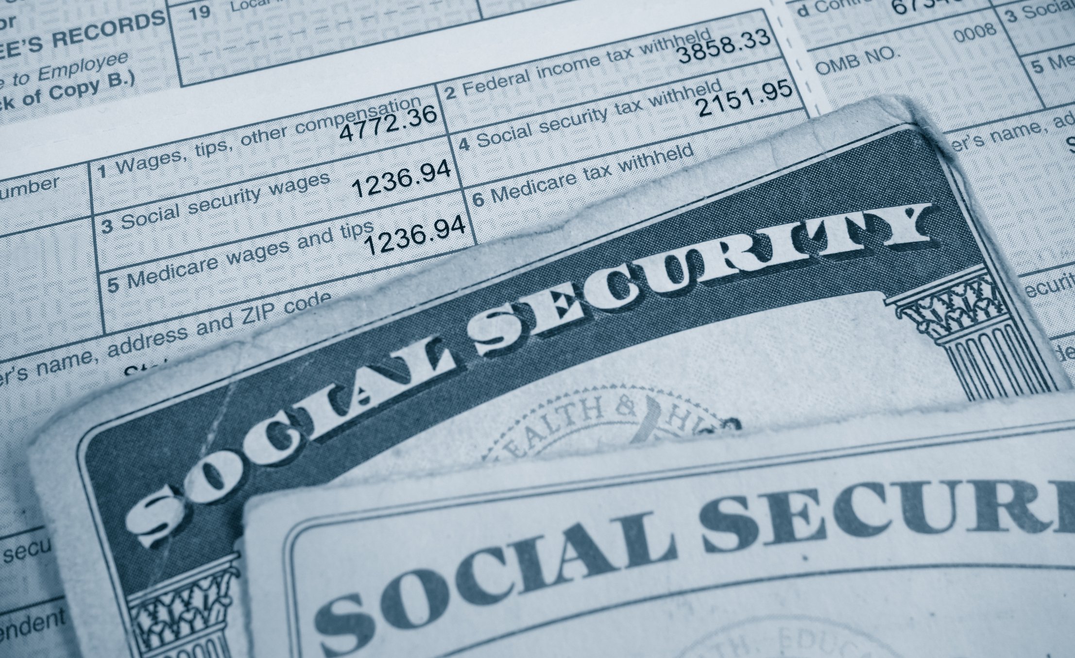 Two Social Security cards on top of a tax form.