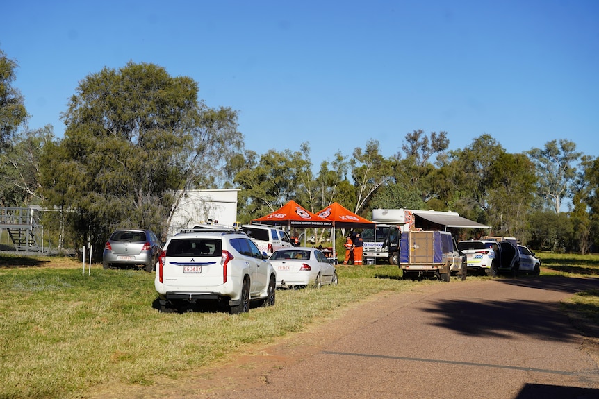 A search and rescue set up with tents and police cars 