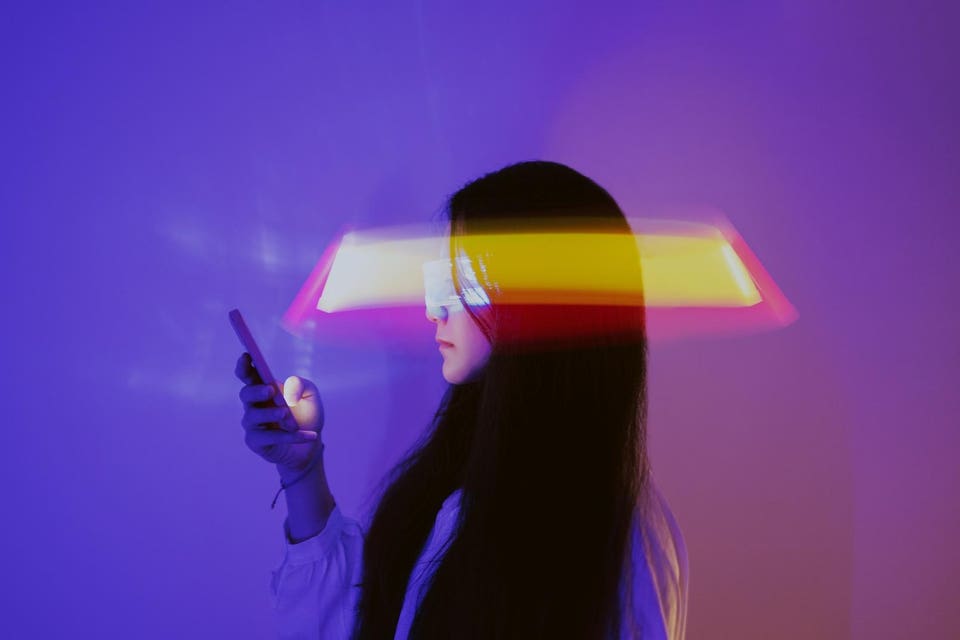 Woman using smartphone surrounded by beams of light