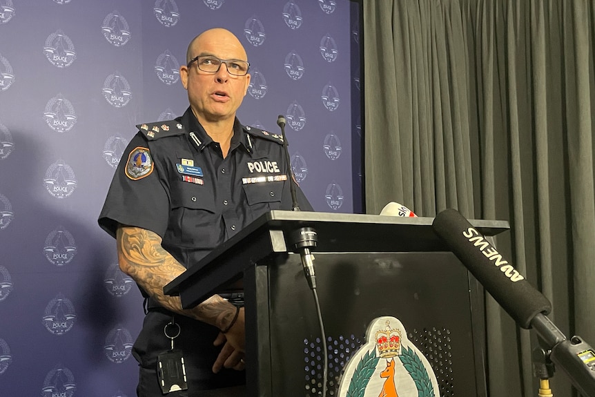 A police officer speaking at a lectern.