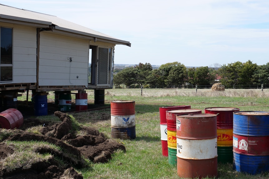 a home stacked on oil drums with oil drums in foreground