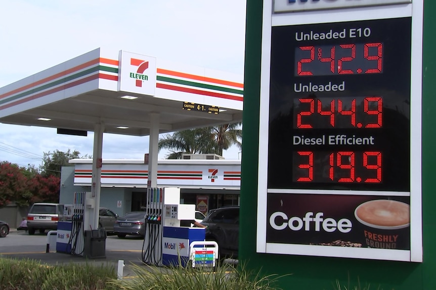 An electronic sign showing the price of petrol and diesel beside a petrol station with 7-11 signage.